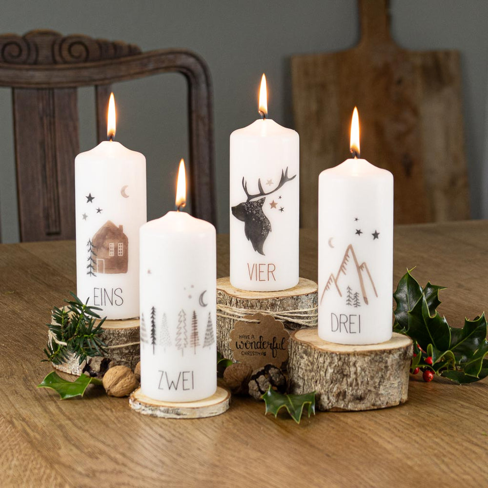 Vier Adventskerzen Zuhause mit Aquarellmotiven für den Advent