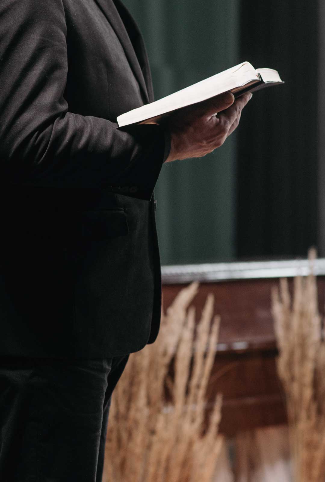 Pfarrer mit Buch auf der Beerdigung