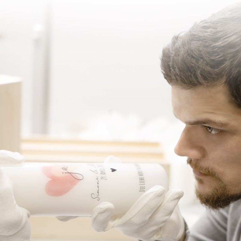 Basti kontrolliert mit Baumwollhandschuhen individuelle Hochzeitskerze