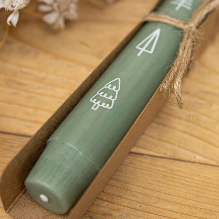 Stabkerze in Grün zu Weihnachten als Geschenk in einer Verpackung