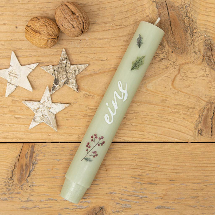 Stabkerze Advent mit der Zahl Eins und Blättern als Motiv auf grüner Kerze