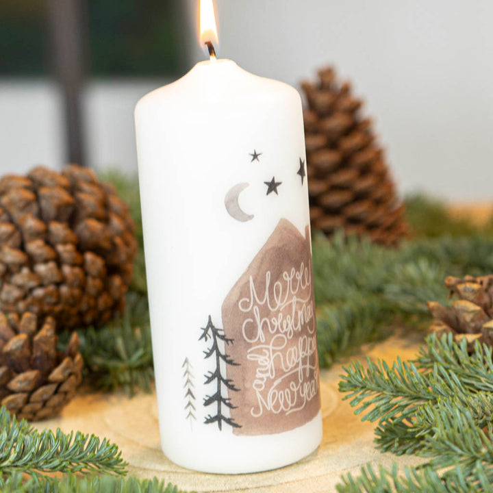 Weihnachtskerze Merry Christmas mit Haus und Bäumen als Motiv