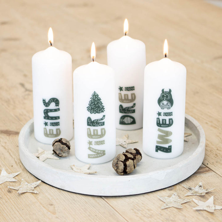 Adventskerzen mit Zahlen Hygge auf einer Betonschale