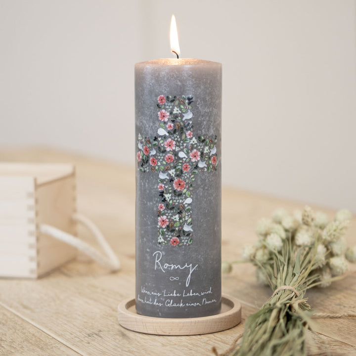 Taufkerze mit einem floralen Kreuz auf einer Rustic Beton grauen Kerze